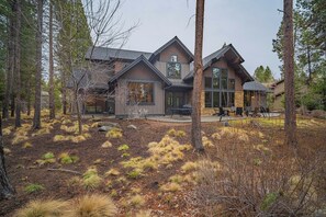 A modern house with a large deck, surrounded by a forested area. - Forest View Hideaway with Access to Forest House (Sunriver)