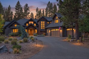 A large, multi-story house with a prominent garage and a driveway leading to the entrance. - Forest View Hideaway with Access to Forest House (Sunriver)