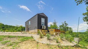 Une maison de plain-pied, à l’extérieur sombre, avec un appareil de climatisation visible.