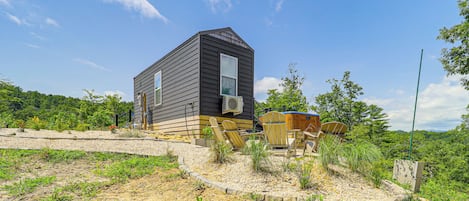 A single-story house with a dark exterior and a visible air conditioning unit.