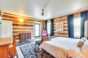 Une chambre à coucher de style chalet, avec un grand lit, une commode en bois, une chaise et un bureau.