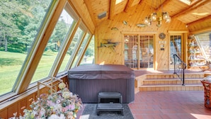 A wooden cabin with a hot tub, large windows, and a staircase leading to a deck. - Pond & Hot Tub! Airy Hudson Valley Escape (Austerlitz)