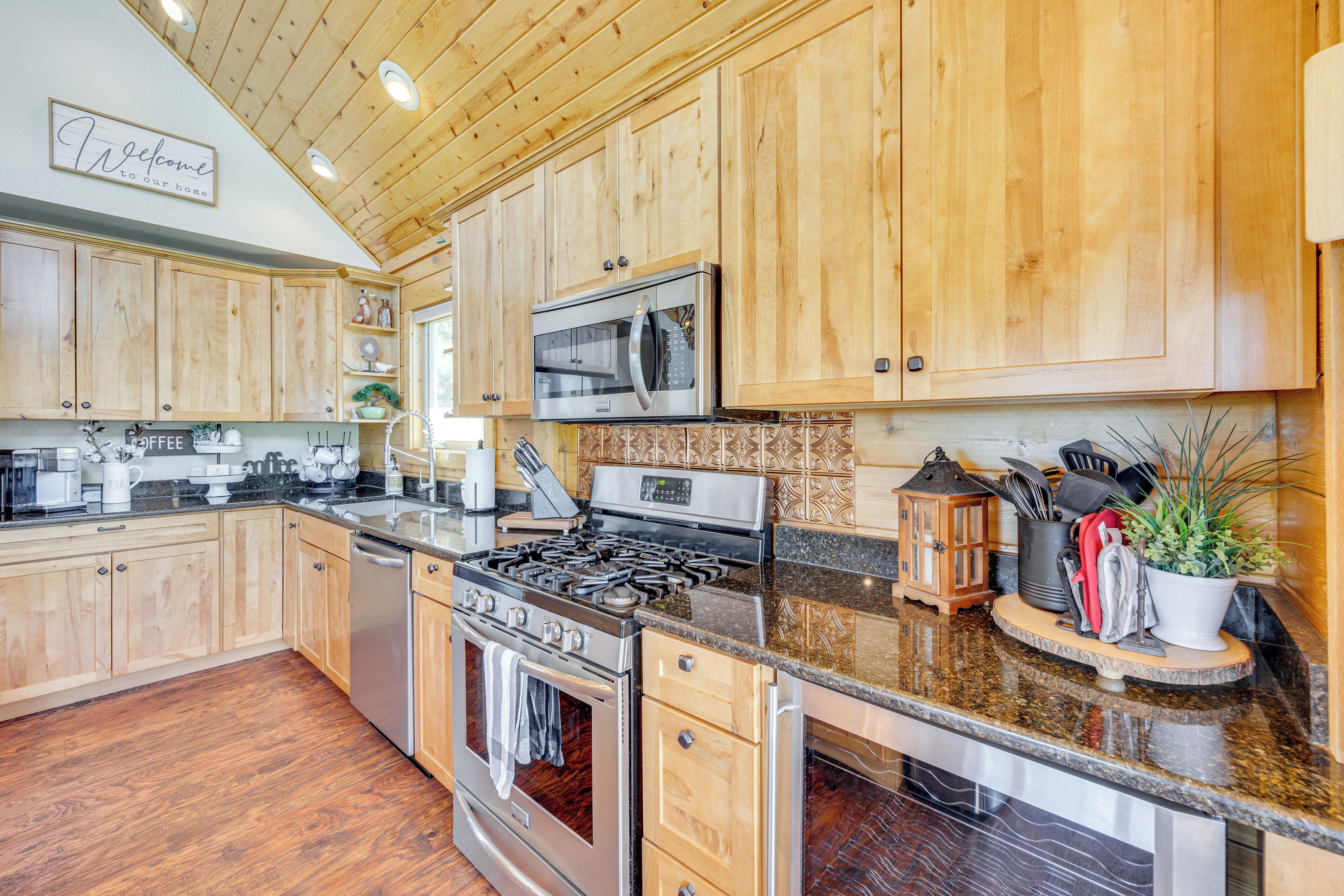 A kitchen with wooden cabinets, a stainless steel stove, and a microwave.
