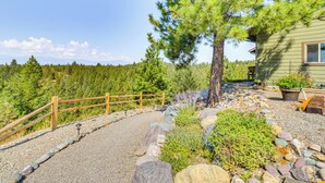 A rustic cabin with a gravel pathway, wooden fence, and a variety of plants and rocks. - Cozy Eureka Getaway - Hike, Bike, Hunt & Fish! (Eureka)