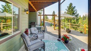 A covered patio with wicker furniture, a table, and potted plants. - Cozy Eureka Getaway - Hike, Bike, Hunt & Fish! (Eureka)