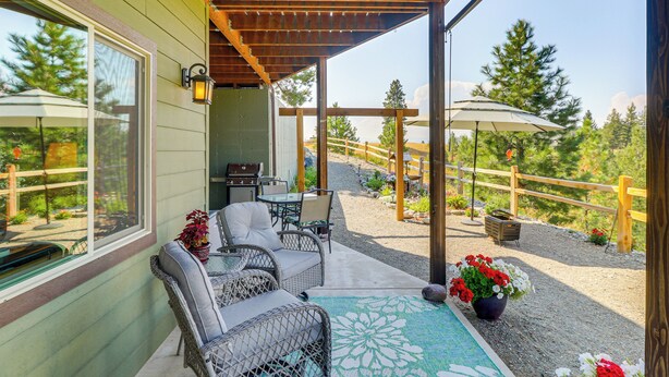 A covered patio with wicker furniture, a table, and potted plants. - Cozy Eureka Getaway - Hike, Bike, Hunt & Fish! (Eureka)
