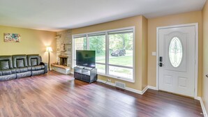 A living room with a fireplace, a sofa, and a television. - 5 Mi to Warren Dunes - Secluded Sawyer Home! (Sawyer)