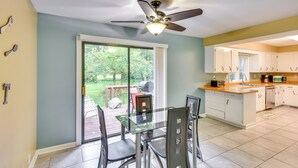 A kitchen with a glass dining table, white cabinets, and a ceiling fan. - 5 Mi to Warren Dunes - Secluded Sawyer Home! (Sawyer)