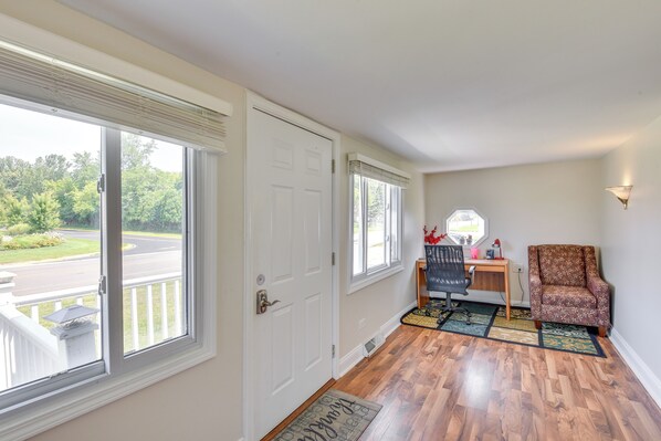 A room with a wooden floor, a white door, a desk with a chair, and a patterned rug. - 3 Mi to Lake Michigan Access: Sawyer Home w/ Patio (Sawyer)
