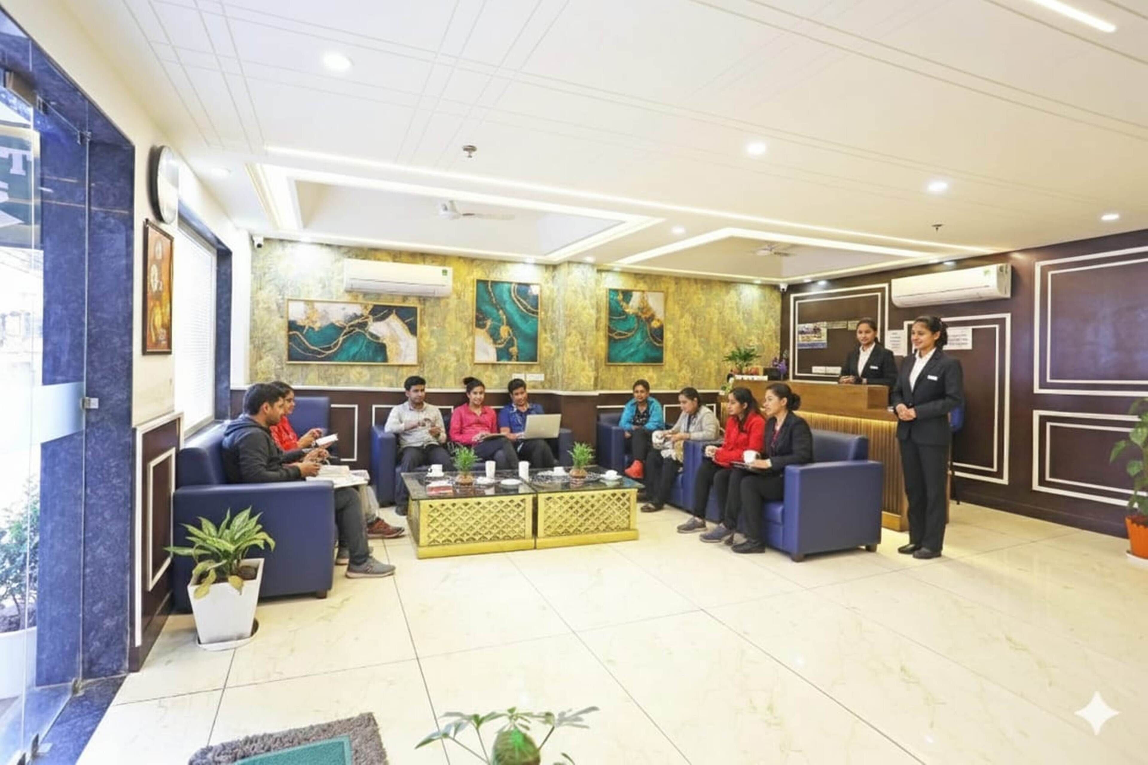 Un hall de hotel con zonas de estar, una recepción y decoración mural.