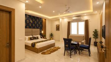A modern bedroom with a bed, a desk, a chair, a television, and an air conditioning unit.