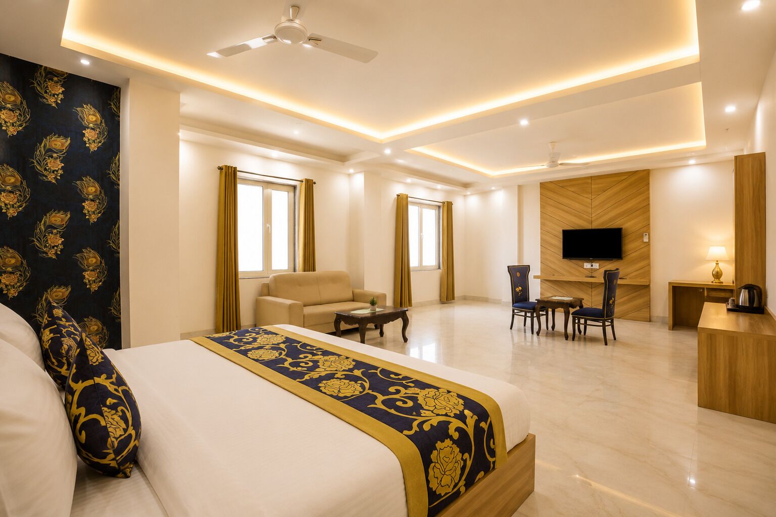 A hotel room with a bed, a desk, a TV, and a seating area.