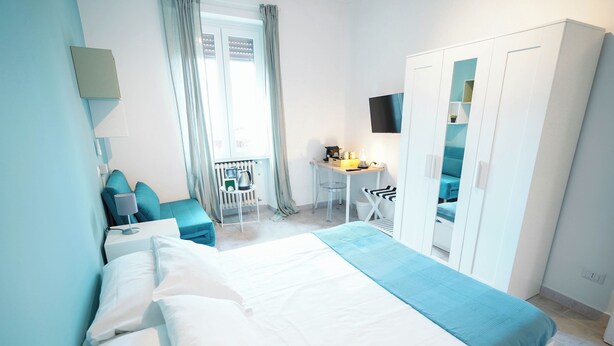 Une chambre à coucher avec un lit, un bureau, une chaise et une armoire.