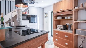 Una cocina moderna con estufa integrada, cafetera y armarios de madera.
