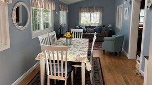 A dining area with a table, chairs, and a ceiling fan.