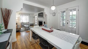 Una cocina moderna con una isla grande, armarios blancos y una lámpara colgante.