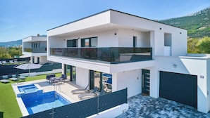 A modern two-story house with a rooftop pool, outdoor seating, and a garage. - Villa Adria Dream by Litto (Kastela)