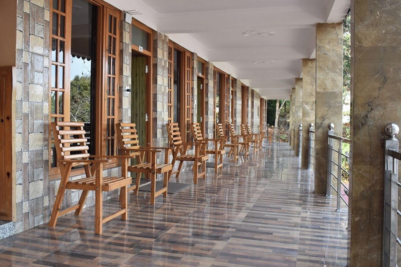 Un pasillo con sillas de madera y paredes de piedra.