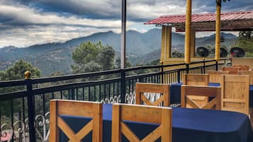 Eine Terrasse mit Holzmöbeln und Blick auf schneebedeckte Berge.