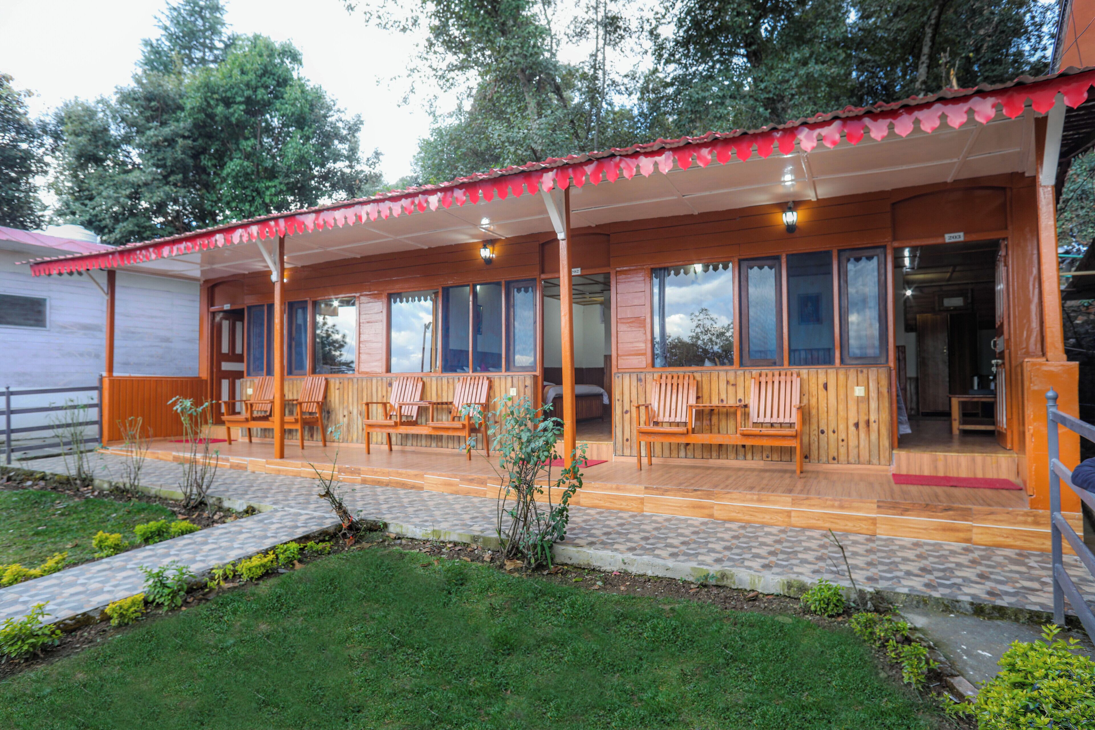 A wooden building with a covered patio area, multiple windows, and outdoor seating.
