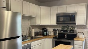 A modern kitchen with white cabinets, stainless steel appliances, and a central island. - Charming and immaculate 1-bedroom Suite/Apartment in Elizabethton  (Elizabethton)