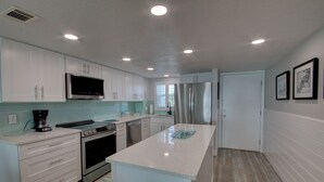 A modern kitchen with white cabinets, stainless steel appliances, and a central island. - 331 El Matador 2 Bedroom Home by RedAwning (Fort Walton Beach)