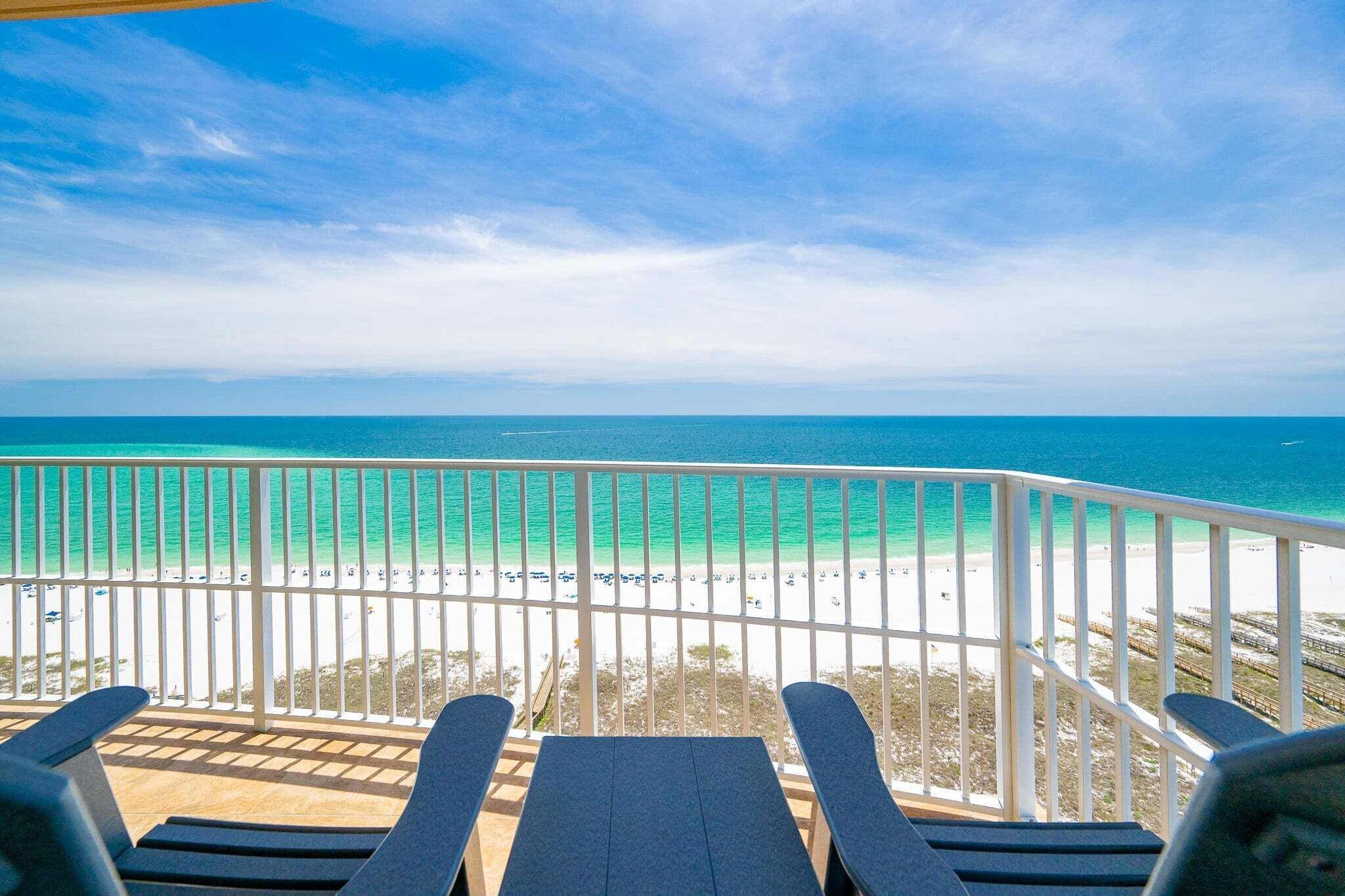 A balcony with a view of a beach and ocean.