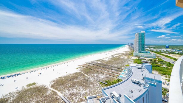 A beach with a hotel, clear blue sky, and ocean. - Phoenix Orange Beach Ii 1701 4 Bedroom Condo by RedAwning (Orange Beach)