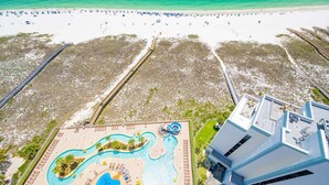 An aerial view of a resort with a beach, a pool area, and a modern building. - Phoenix Orange Beach Ii 1701 4 Bedroom Condo by RedAwning (Orange Beach)