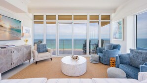 A spacious living room with a large window overlooking the ocean, a round coffee table, and a sofa. - Phoenix Orange Beach Ii 1701 4 Bedroom Condo by RedAwning (Orange Beach)