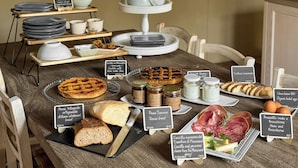 Ein reichhaltiges Frühstücksbuffet mit verschiedenen Speisen und Beschriftungen.