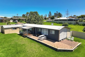 A single-story house with a patio, a covered outdoor seating area, and a satellite dish.