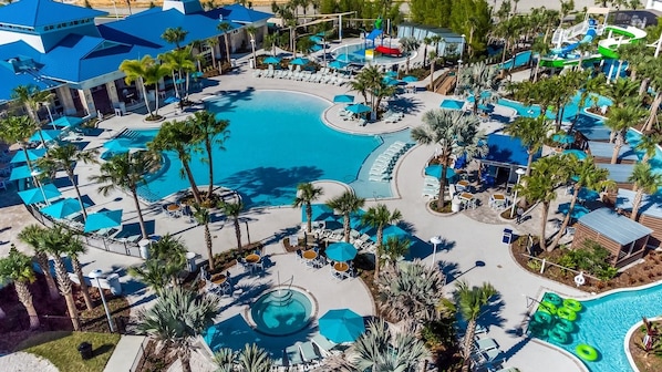 A resort with multiple swimming pools, sun loungers, and palm trees.