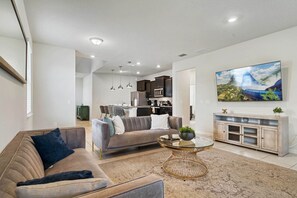 A modern living room with a sofa, coffee table, and a painting on the wall.