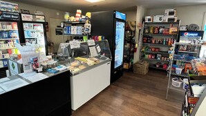 Ein Kiosk mit Kühlregal, Regalen voller Snacks und einer Verkaufstheke.