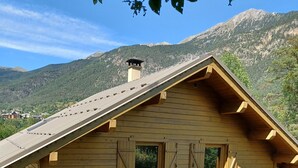 A wooden chalet with a sloped roof, multiple windows, and a satellite dish. - Chalet Briançon Serre Chevalier (Briançon)