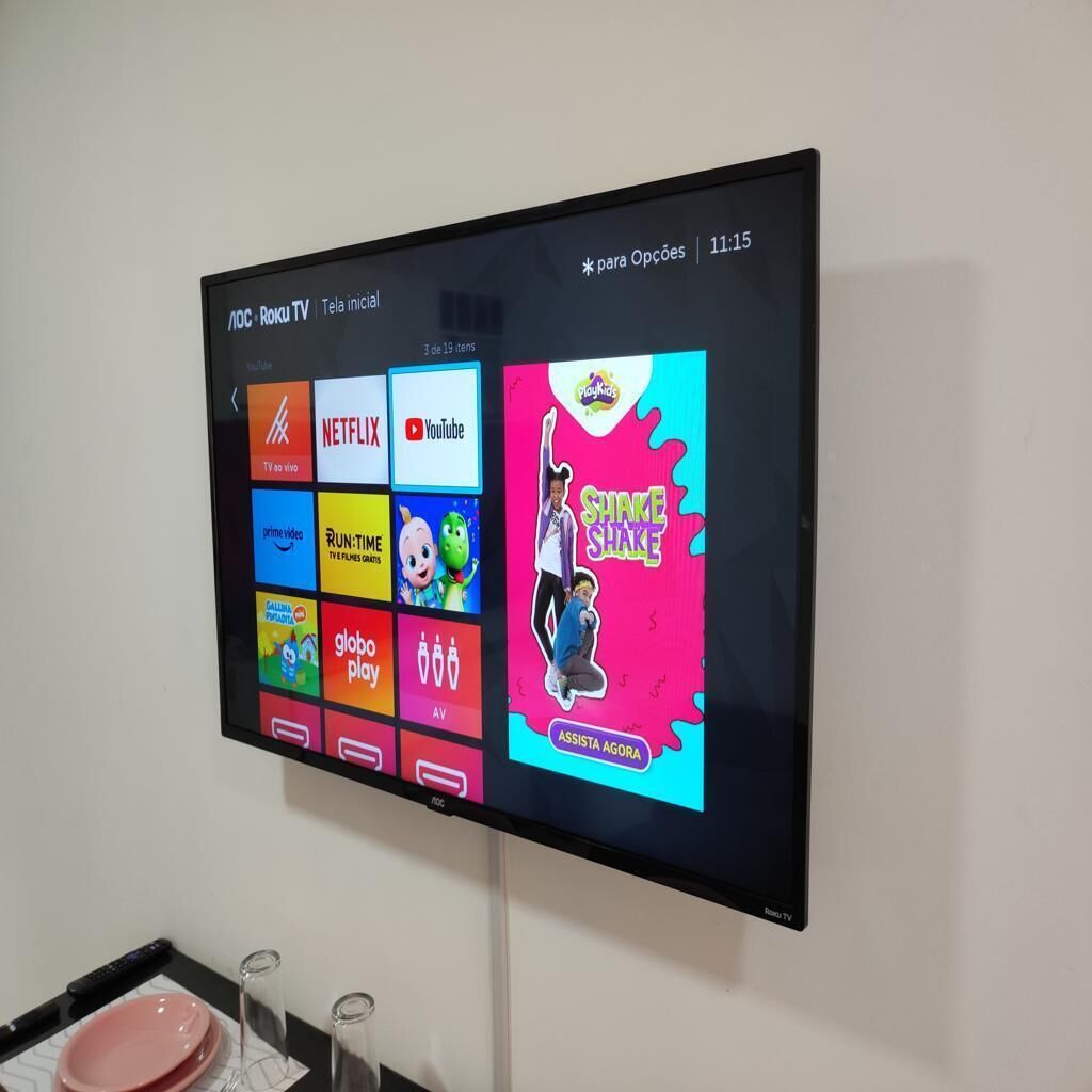A flat-screen TV mounted on a wall displaying various streaming service icons.