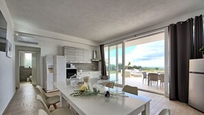 A modern kitchen with a dining area, large sliding glass doors to a patio, and a view of the outdoors.