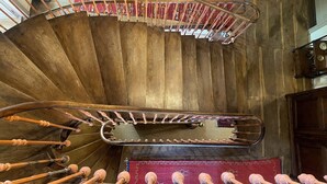 A wooden spiral staircase with a metal handrail and wooden balusters. - Auberge des Hirondelles (Puycelci)