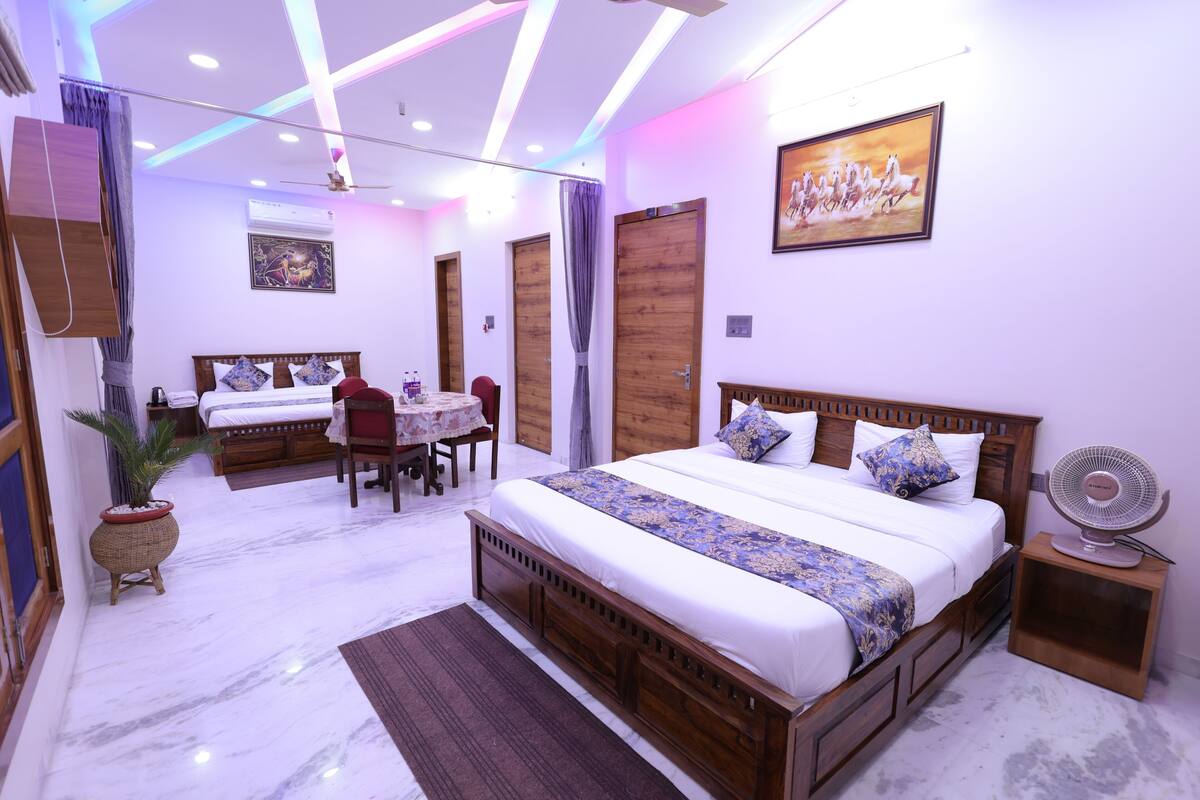 A modern bedroom with a wooden bed, a dining table, and a fan.