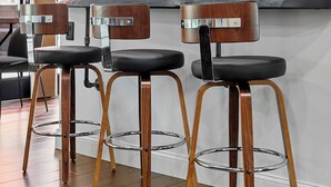 A modern kitchen with three bar stools, wooden legs, and black seats. - Heated Pool | Game Room | Arcade | Sleeps14 | BBQ (Bradenton)