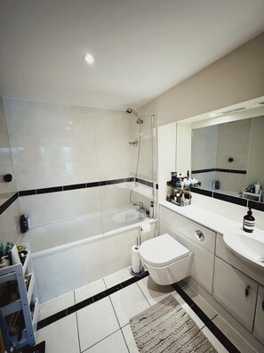Relax in a spacious bathroom with a bathtub and separate sink area.