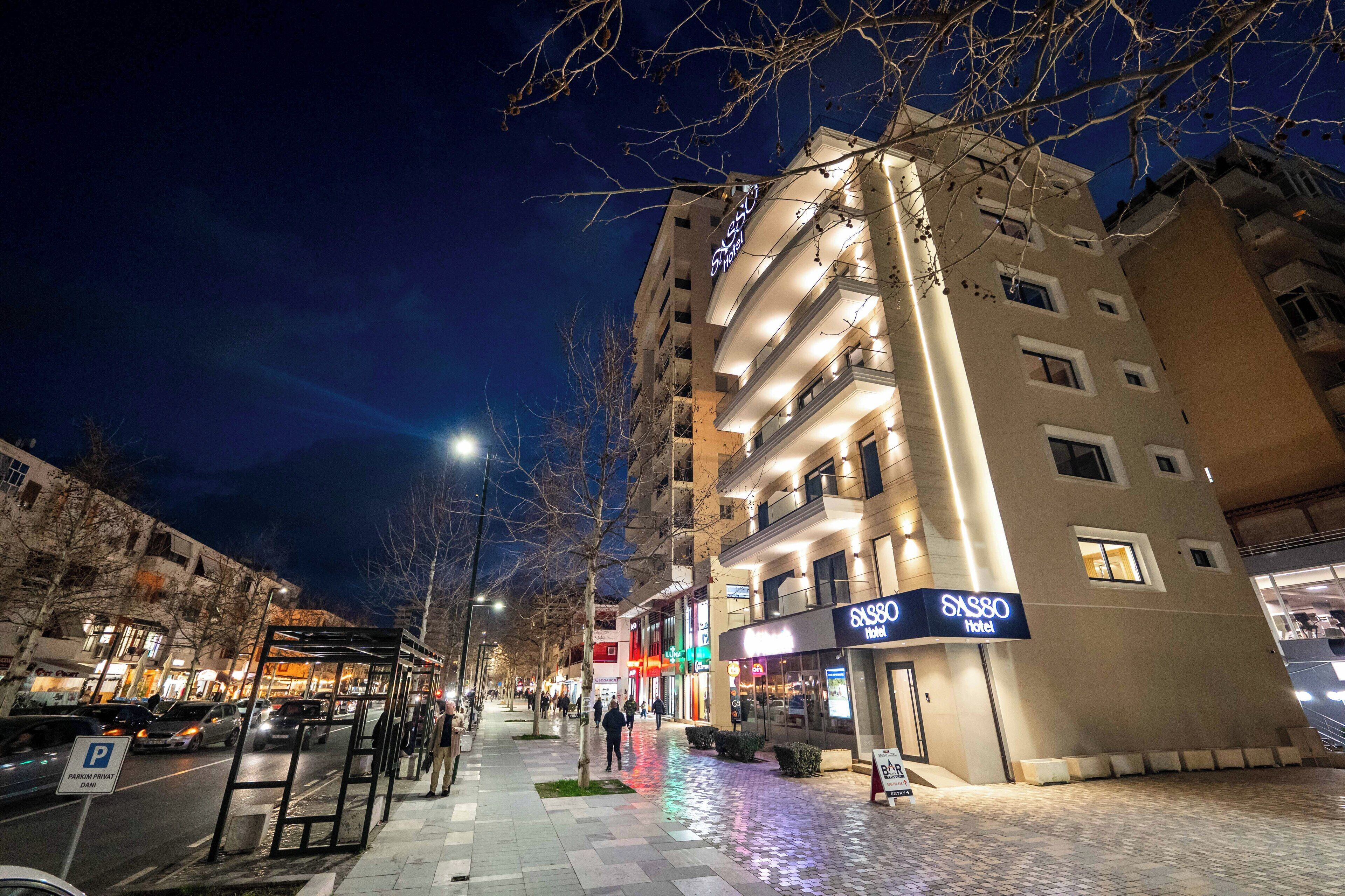 A hotel with multiple floors, a covered bus stop, and a pedestrian walkway.