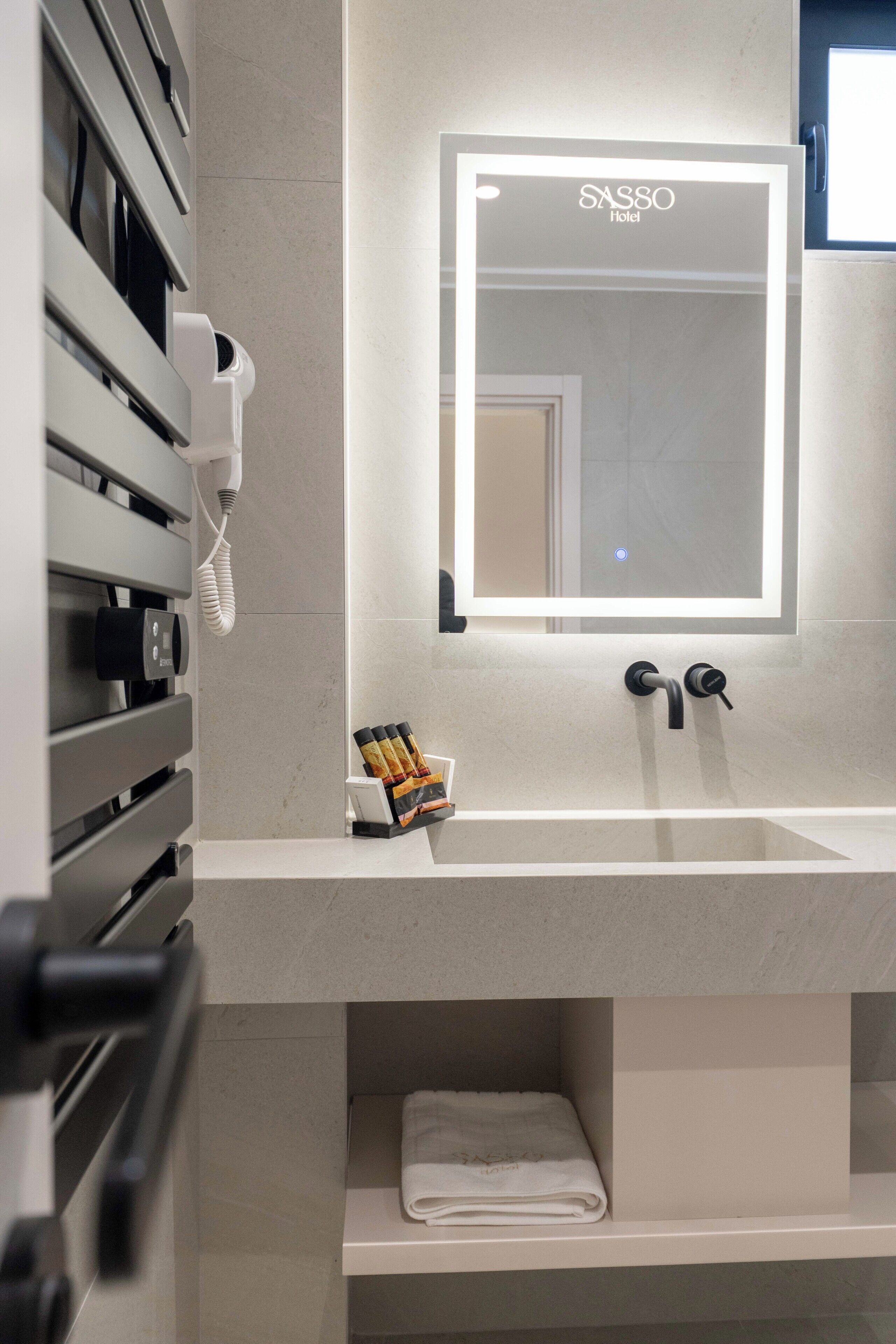 Ein Badezimmer mit Spiegel, Waschbecken und Handtuchhalter.