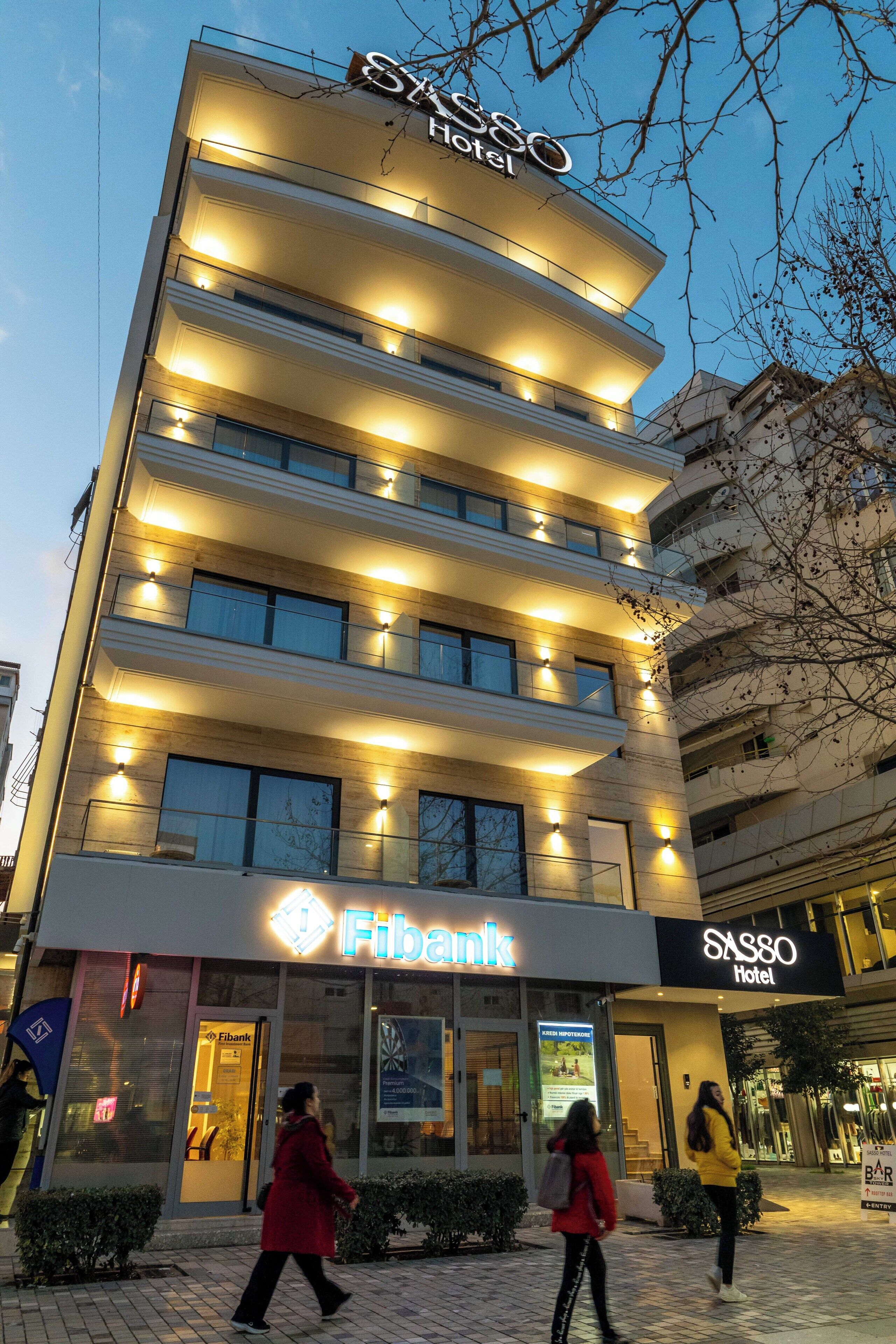 Un hôtel à plusieurs étages, doté d’une enseigne lumineuse, d’une entrée bien visible et situé à proximité d’une banque.