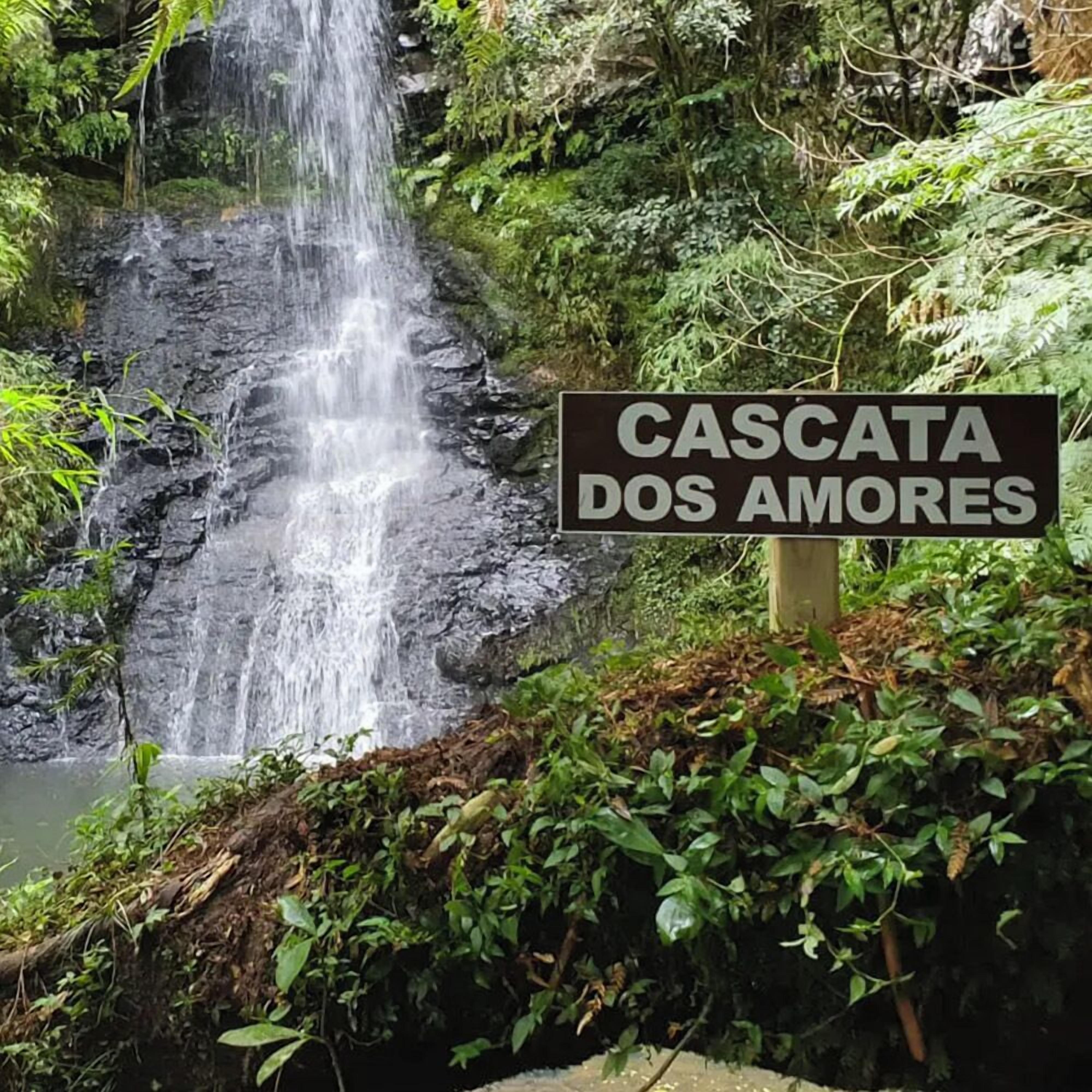 A sign reading "CASCATA DOS AMORES" in front of a waterfall.