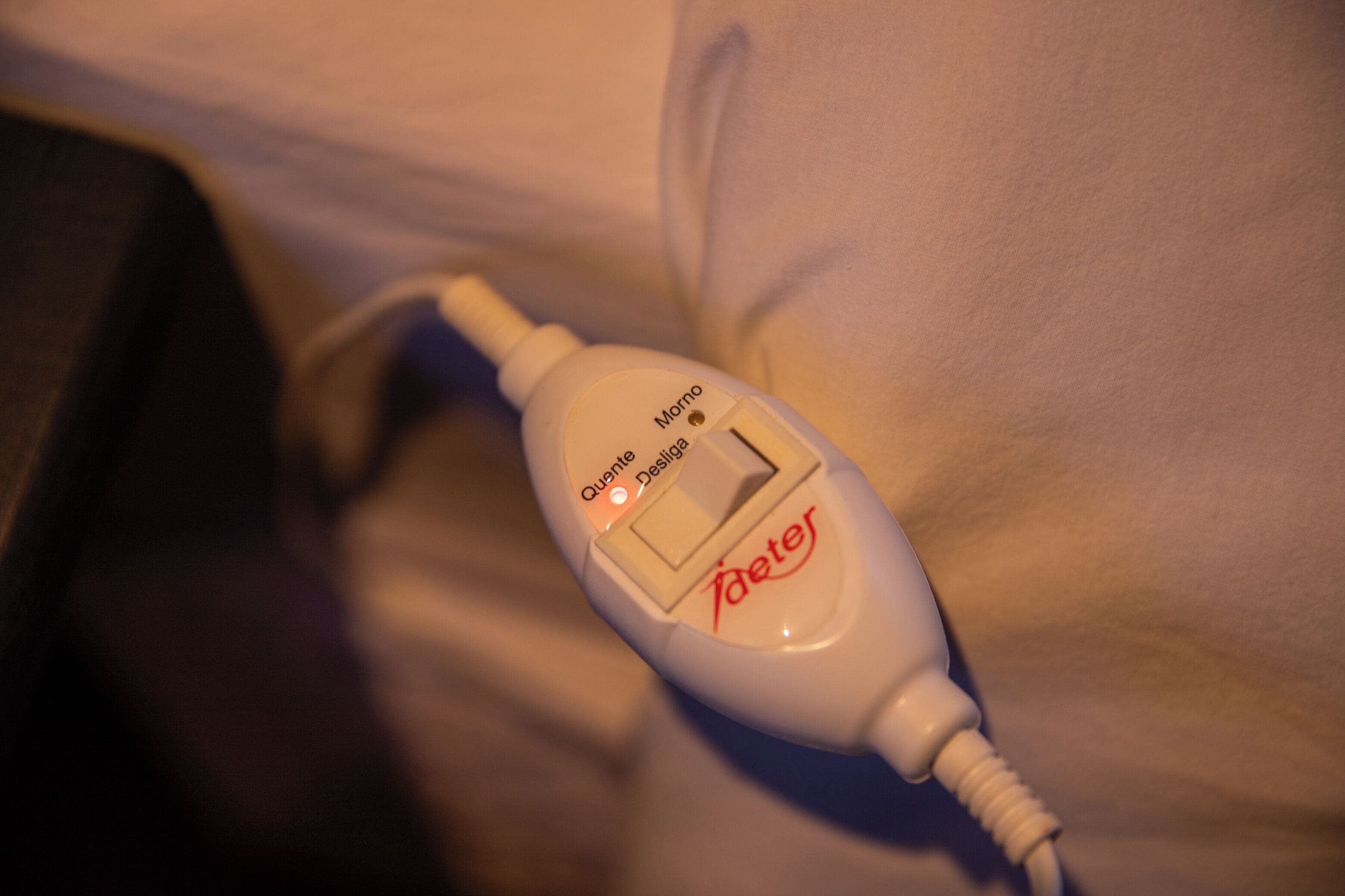 A white bedside table with a white device on it, possibly a medical or electronic device, with text and buttons visible.