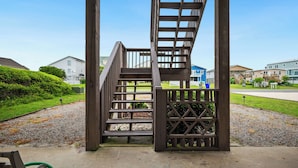 A wooden staircase leading to a covered area with a view of residential buildings.