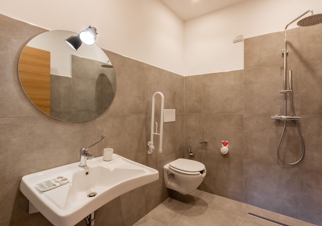 A modern bathroom with a sink, toilet, and shower.