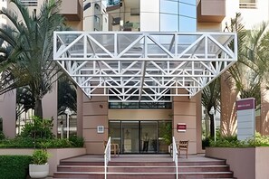Stunning entrance with a striking geometric design above the entrance, flanked by steps leading up to a glass door.